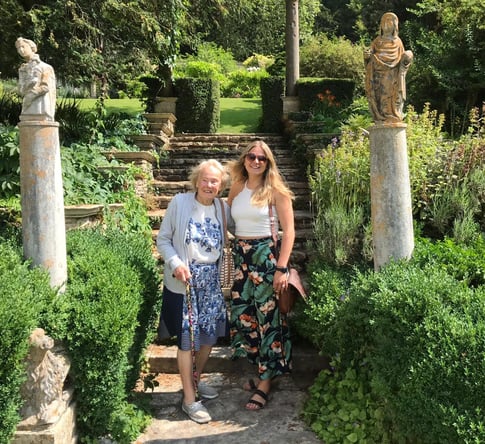 The author with her grandma stood together at the base of an ornate set of garden stairs